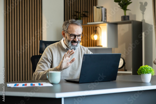 Cuadro en lienzo Smiling man connecting remotely from home office, participating in a virtual mee
