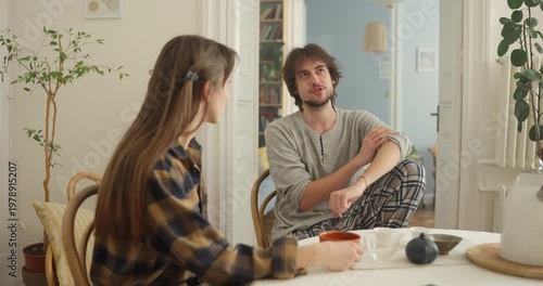 Two friends relax in a warm, inviting apartment, engaged in deep conversation as they share their thoughts and dreams