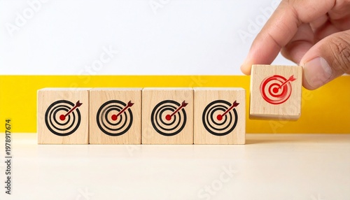 Hand Completing a Row of Target Icons with a Red Goal Cube for Business Success