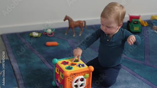Young one explores colorful sorting toys. Exploring shapes in cozy environment by child. Infant improving fine motor skills and cognitive development through fun activities that encourage learning