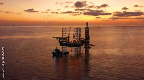 Aerial top view of offshore jack up rig and offshore platform during sunset for oil and gas exploration and production. 

