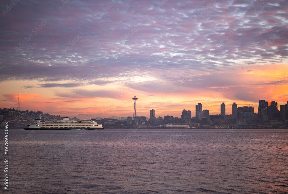 Naklejka premium A commuter ferry passing the Seattle skyline in Elliott Bay at sunrise 