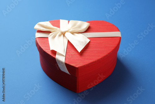 Beautiful heart shaped box on blue background, closeup