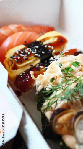 Savor freshly prepared sushi rolls and delicacies served in elegant takeout boxes at a serene lunchtime gathering