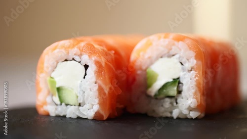 Delightful sushi rolls filled with cucumber and cream cheese elegantly displayed on a slate surface in a warm atmosphere.