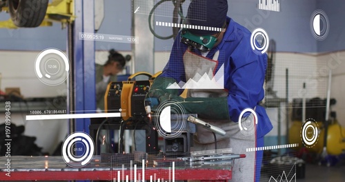 Canvas Print Using grinder technician in blue coveralls cutting clamped metal on red bench at