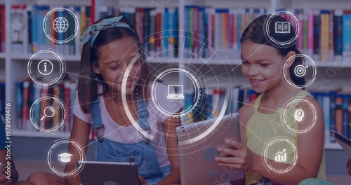 Holding tablets, two student girls in overalls and yellow dress learning at library bookshelf, HUD