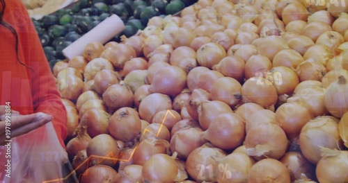 Showing onions filling sloped produce bin at market, shopper in orange red jacket holding clear bag