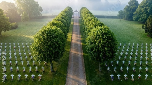 Aerial View of Military Cemetery Memorial at Sunrise with White Crosses and Misty Morning Fog Over Green Grass