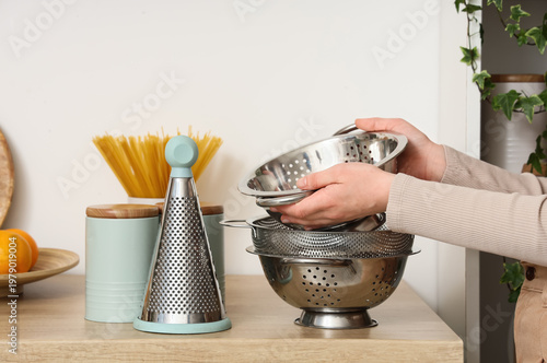 Woman with metal colanders ...