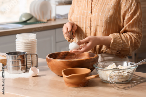 Woman breaking egg into bow...