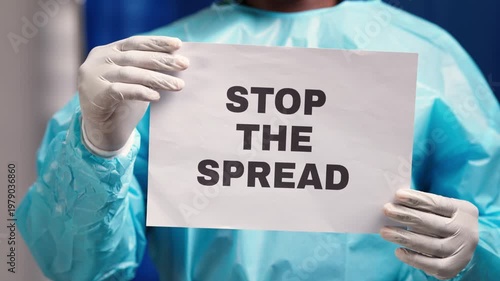 African medical professional in ppe holding a sign urging public to stop the spread