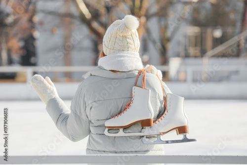 Young woman with ice skates...