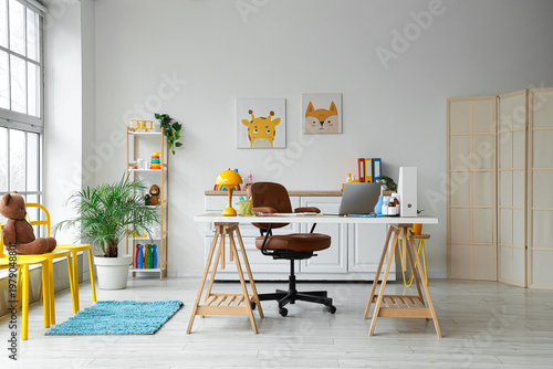Interior of pediatrician's office with workplace, shelf unit and toys