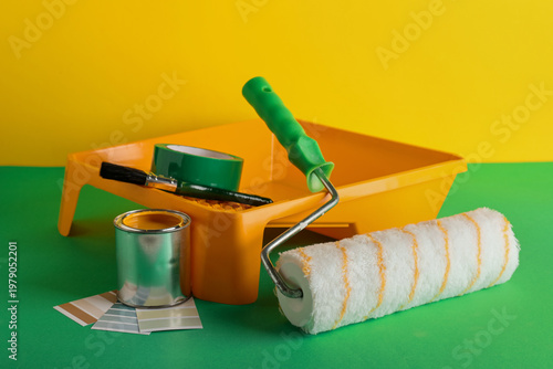 Can of paint with roller, c...