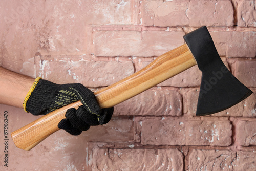 Hand in glove holding ax on...
