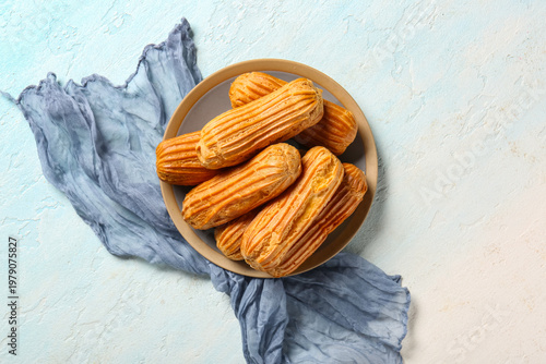 Plate with tasty eclairs on...