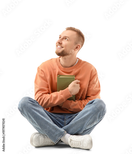Happy young man hugging book on white background