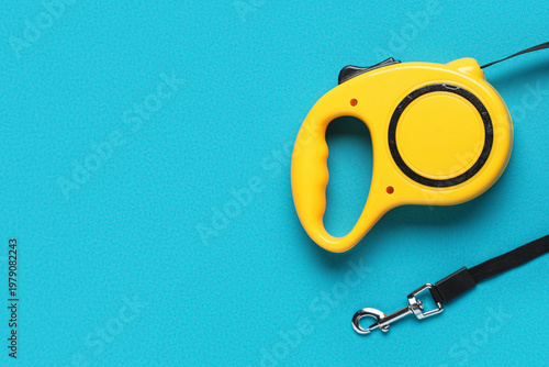 Foto Yellow retractable dog leash with lead on blue background