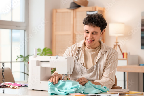 Young male tailor using sew...