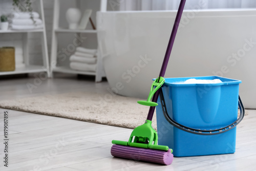 Mop with blue bucket of wat...