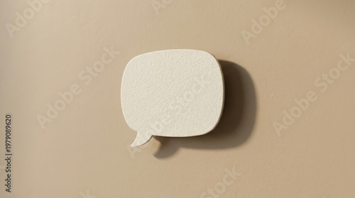 Minimalist white speech bubble symbol with textured surface on a beige background modern design clean lighting shadow detail