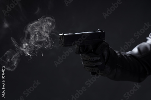 фотографія Male hand with smoking gun on black background
