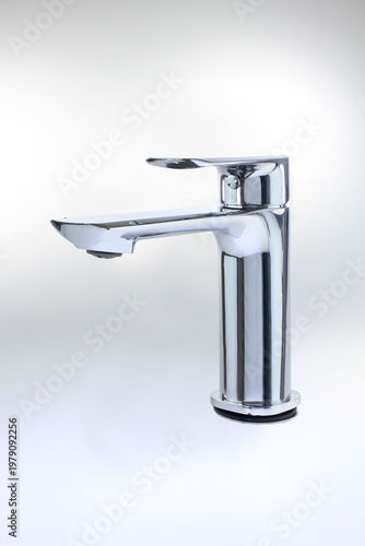 Modern chrome faucet stands sleekly against a soft white background. Its design emphasizes clean lines and minimalist elegance. isolated on clean white background with soft shadow, functional tools.