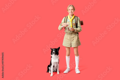 Cuadro en lienzo Boy scout with cute Border Collie dog and thermos on red background