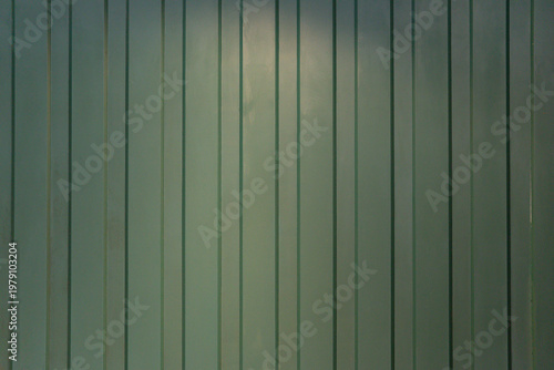 Foto Green corrugated metal wall texture with gentle lighting and neutral tones