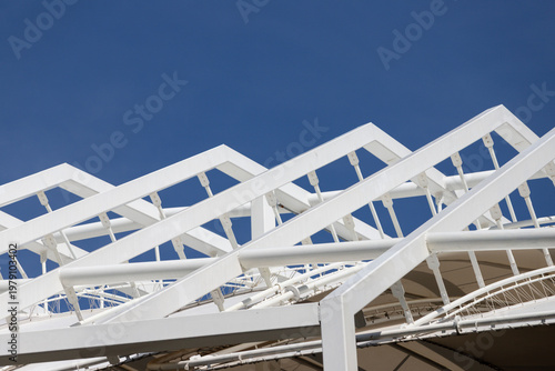 Foto Sleek white metal framework stands tall under bright blue sky