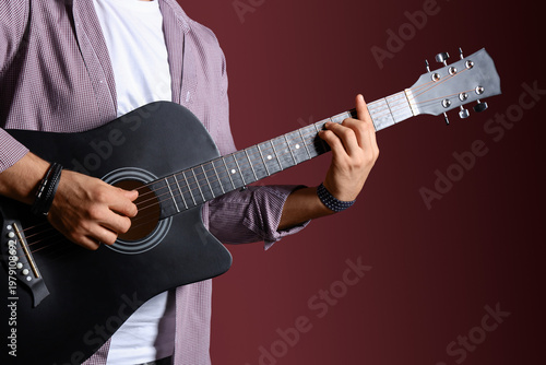 Young man playing guitar on...