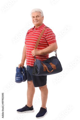 Senior man with boxing gloves and sports bag on white background