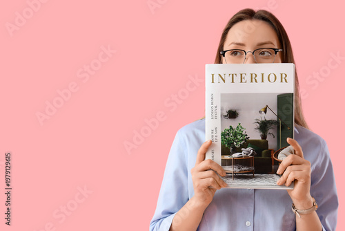 Beautiful young woman in eyeglasses with magazine on pink background