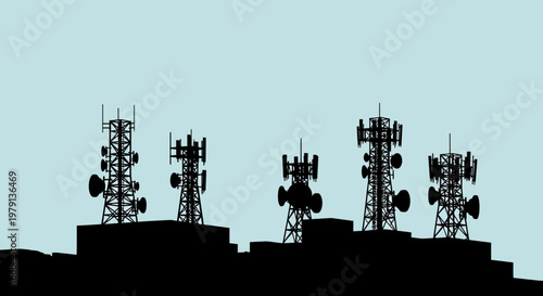 Telecommunication towers silhouette on building rooftop against blue sky representing wireless network connection