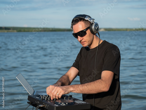 Caucasian man works as a DJ on the beach. 