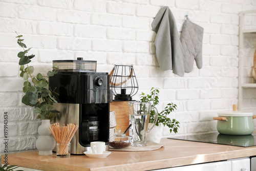 Tableau sur toile Modern coffee machine, stirrers and cup on counter in kitchen
