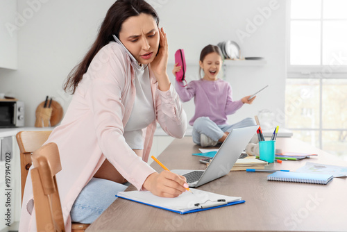 Stressed mother working fro...