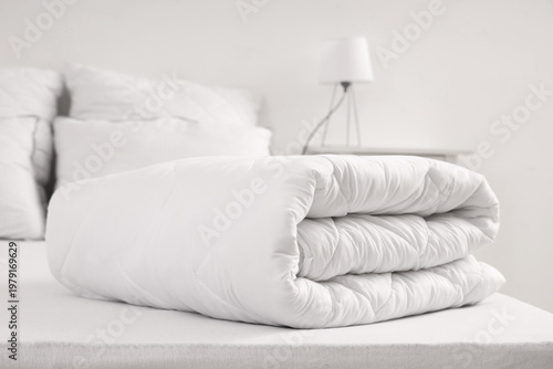 Folded white blanket on bed...