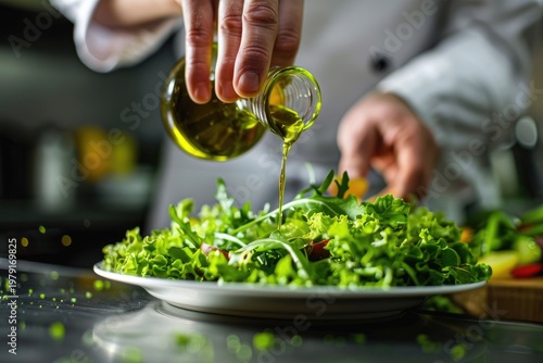 Chef Drizzling Olive Oil on Fresh Green Salad in Professional Kitchen.