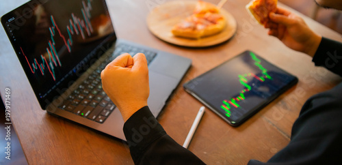 Business professionals are analyzing stock market charts on their laptops, typing in data, planning investments, reviewing reports, forecasting trends, and achieving financial success in a corporate 