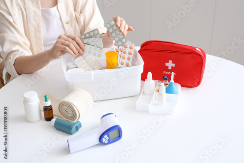 Woman putting pills into ho...