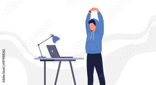 Man in blue hoodie stretching at desk with laptop and lamp