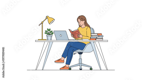 Young woman sitting at a modern desk reading a book next to an open laptop and a study lamp for education and remote work concepts.
