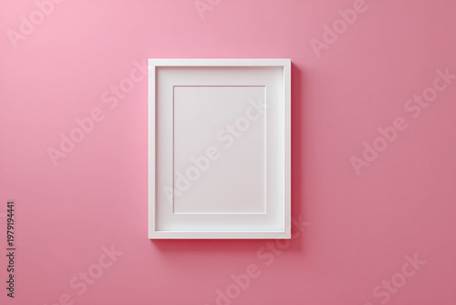Empty white picture frame mounted on a solid blush pink wall, providing a clean minimalist mockup for digital art.