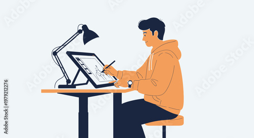 Young man drawing on digital tablet at desk with lamp, creative workspace