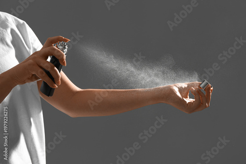 Young woman spraying elegan...