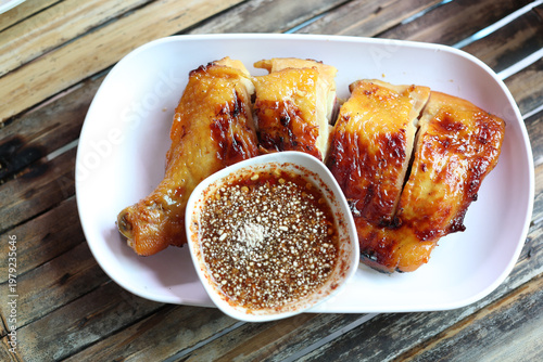 Chopped grilled chicken is placed in a plastic dish with sauce.