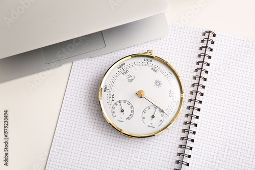 Quadro su tela Notebook with aneroid barometer and modern laptop on white table, closeup
