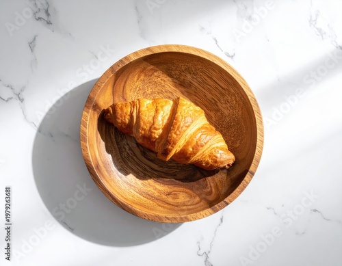 Flaky croissant in wooden bowl on marble surface (1)
